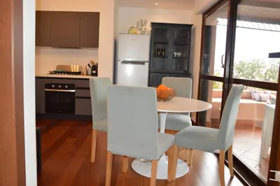 a kitchen with a table and chairs in a room at Appartamento con vista in Palermo