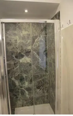 a shower with a glass door in a bathroom at Appartamento con vista in Palermo