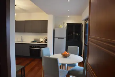 a kitchen with a table and chairs and a white refrigerator at Appartamento con vista in Palermo