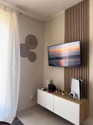 a living room with a tv on a wall at Casa Tulum - Sea View & Breakfast in Palermo