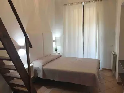 a small bedroom with a bed and a staircase at Apartment Via Vittorio Emanuele & Vucciria in Palermo