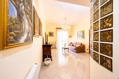 a living room with a couch and paintings on the wall at MG Apartment in Palermo