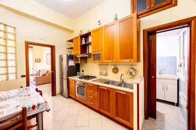 a kitchen with wooden cabinets and a sink at MG Apartment in Palermo