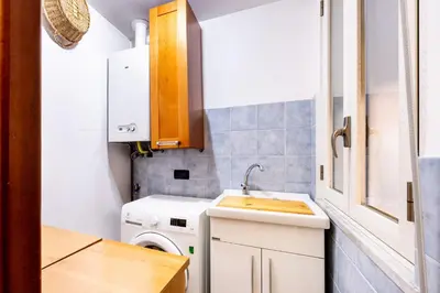 a small kitchen with a sink and a washing machine at MG Apartment in Palermo