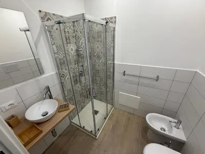 a bathroom with a shower and a toilet and a sink at Bart165 Luxury Rooms in Palermo