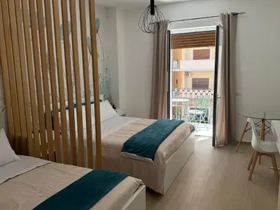 a bedroom with two beds and a sliding glass door at Bart165 Luxury Rooms in Palermo