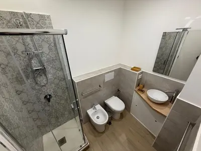 a bathroom with a shower and a toilet and a sink at Bart165 Luxury Rooms in Palermo