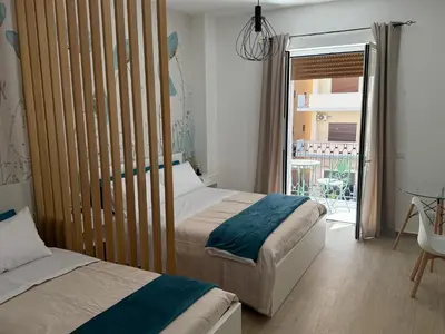 a bedroom with two beds and a door to a balcony at Bart165 Luxury Rooms in Palermo