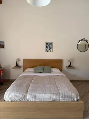 a bedroom with a large bed with a wooden headboard at Risvegliarsi a Danisinni in Palermo
