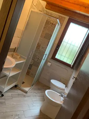 a bathroom with a toilet and a sink and a window at Risvegliarsi a Danisinni in Palermo