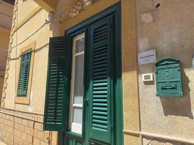 a window and a green shutter on the side of a building at Arco Apartment in Bagheria