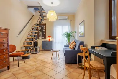 a living room with a blue couch and stairs at Prospettiva Ballarò - Sotto la cupola in Palermo