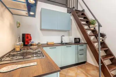 a kitchen with a stove top oven next to a staircase at Prospettiva Ballarò - Sotto la cupola in Palermo
