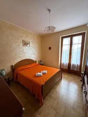 a bedroom with a bed with an orange blanket at Seaside in Santa Flavia