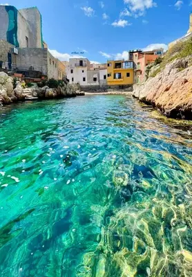 a body of water with a group of buildings at Seaside in Santa Flavia