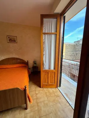 a bedroom with a bed and a sliding glass door at Seaside in Santa Flavia