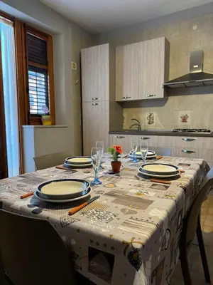 a table with plates and glasses on it in a kitchen at Seaside in Santa Flavia