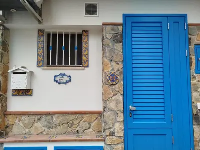 a blue door of a house with a window at Home sweet home in Santa Flavia