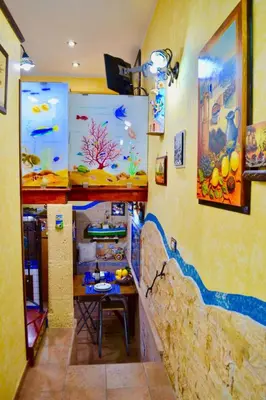 a kitchen with a table and an aquarium on the wall at Home sweet home in Santa Flavia
