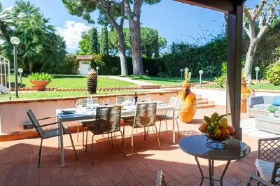 a patio with tables and chairs on a brick patio at Donna Amalia villa in Mondello in Palermo