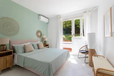 a white bedroom with a bed and a window at Donna Amalia villa in Mondello in Palermo
