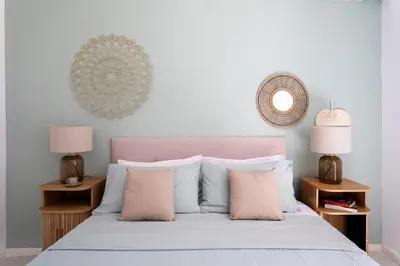 a bed with pink and white pillows and two lamps at Donna Amalia villa in Mondello in Palermo