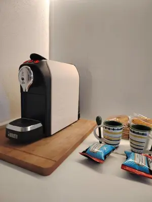 a toaster sitting on a counter next to two cups at Cappuccetto Rosso Sweet Apartment Palermo in Palermo