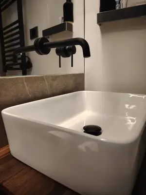 a white bathroom sink with a black faucet at Cappuccetto Rosso Sweet Apartment Palermo in Palermo