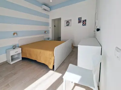 a small bedroom with a bed and a chair at Casa Mo' in Isola delle Femmine