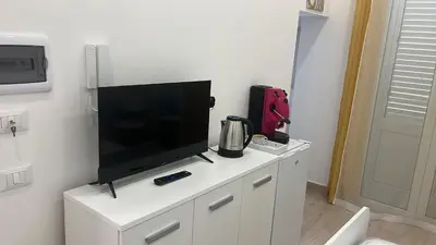 a flat screen tv sitting on top of a white cabinet at Casa Mo' in Isola delle Femmine