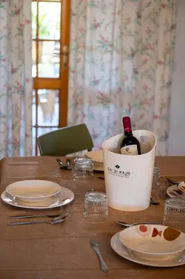 a wooden table with a bottle of wine in a bucket at Clizia Holiday in Campofelice di Roccella