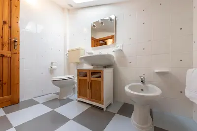 a white bathroom with a sink and a toilet at Clizia Holiday in Campofelice di Roccella