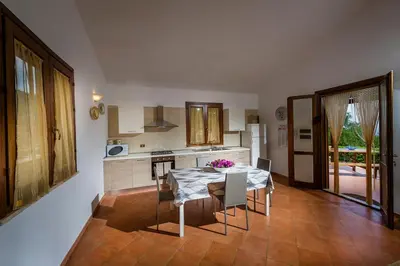 a kitchen with a table and some chairs and a table and a kitchen at Villa del Carrubo in Castellammare del Golfo in Castellammare del Golfo