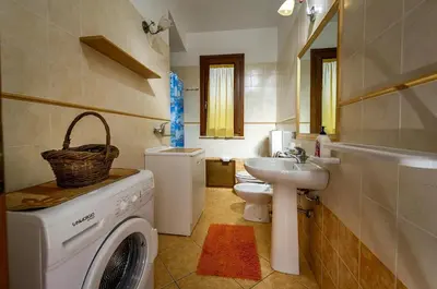 a bathroom with a washing machine and a sink at Villa del Carrubo in Castellammare del Golfo in Castellammare del Golfo