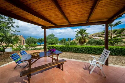 a picnic table and two chairs on a patio at Villa del Carrubo in Castellammare del Golfo in Castellammare del Golfo
