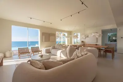a living room with white couches and a dining room at Ammare Luxury Villa by Le Dhome Sicily in Trappeto
