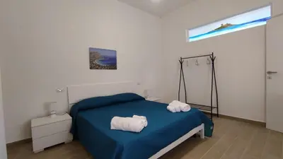 a bedroom with a blue bed with towels on it at Isola delle Femmine vacation home in Isola delle Femmine