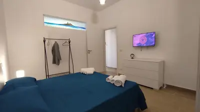a bedroom with a blue bed and a dresser at Isola delle Femmine vacation home in Isola delle Femmine