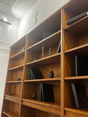 a wooden book shelf with books at Large two-room apartment within walking distance of the Teatro Massimo in Palermo