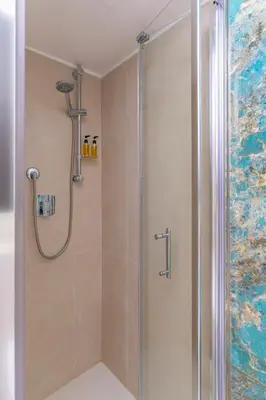 a shower with a glass door in a bathroom at Large two-room apartment within walking distance of the Teatro Massimo in Palermo