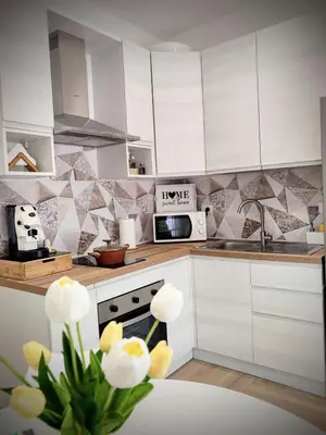 a kitchen with white cabinets and a sink and a microwave at La casa di Zucchero in Monreale