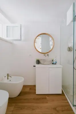a white bathroom with a sink and a mirror at Sea House - Suite vista mare in Terrasini
