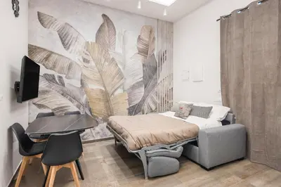 a bedroom with a bed and a desk and a laptop at Casta Diva Fervore Apartments Self Check-in in Palermo
