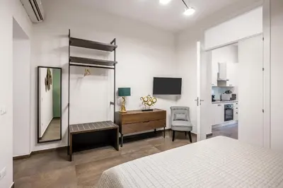 a bedroom with a bed and a desk and a mirror at Casta Diva Fervore Apartments Self Check-in in Palermo