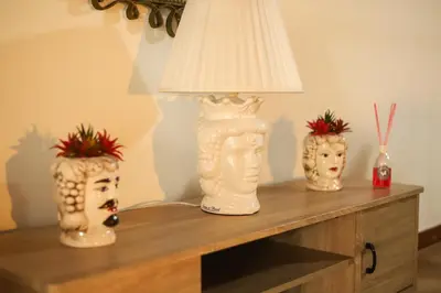 a table with two vases and a lamp on it at Ballarua in Palermo