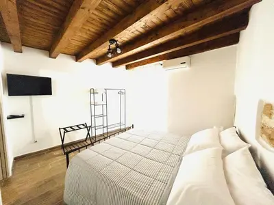 a bedroom with a bed in a room with wooden ceilings at La Casetta in Piazza in Palermo