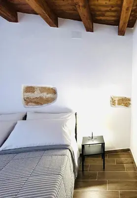 a bedroom with a bed and a side table at La Casetta in Piazza in Palermo
