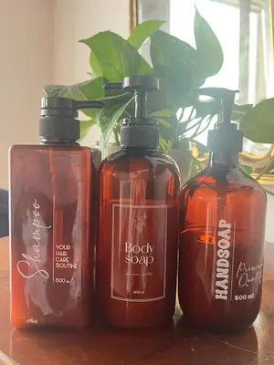 three bottles of soap sitting on a table with a plant at Casa Teré in Palermo