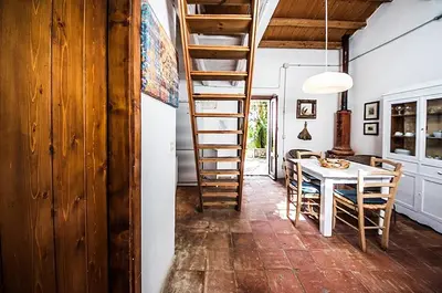 a kitchen and dining room with a ladder and a table at Casa Portico, con piscina in comune in Terrasini