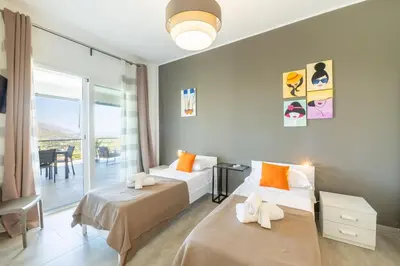 a bedroom with two beds and a balcony at Villa Amelia in Castellammare del Golfo
